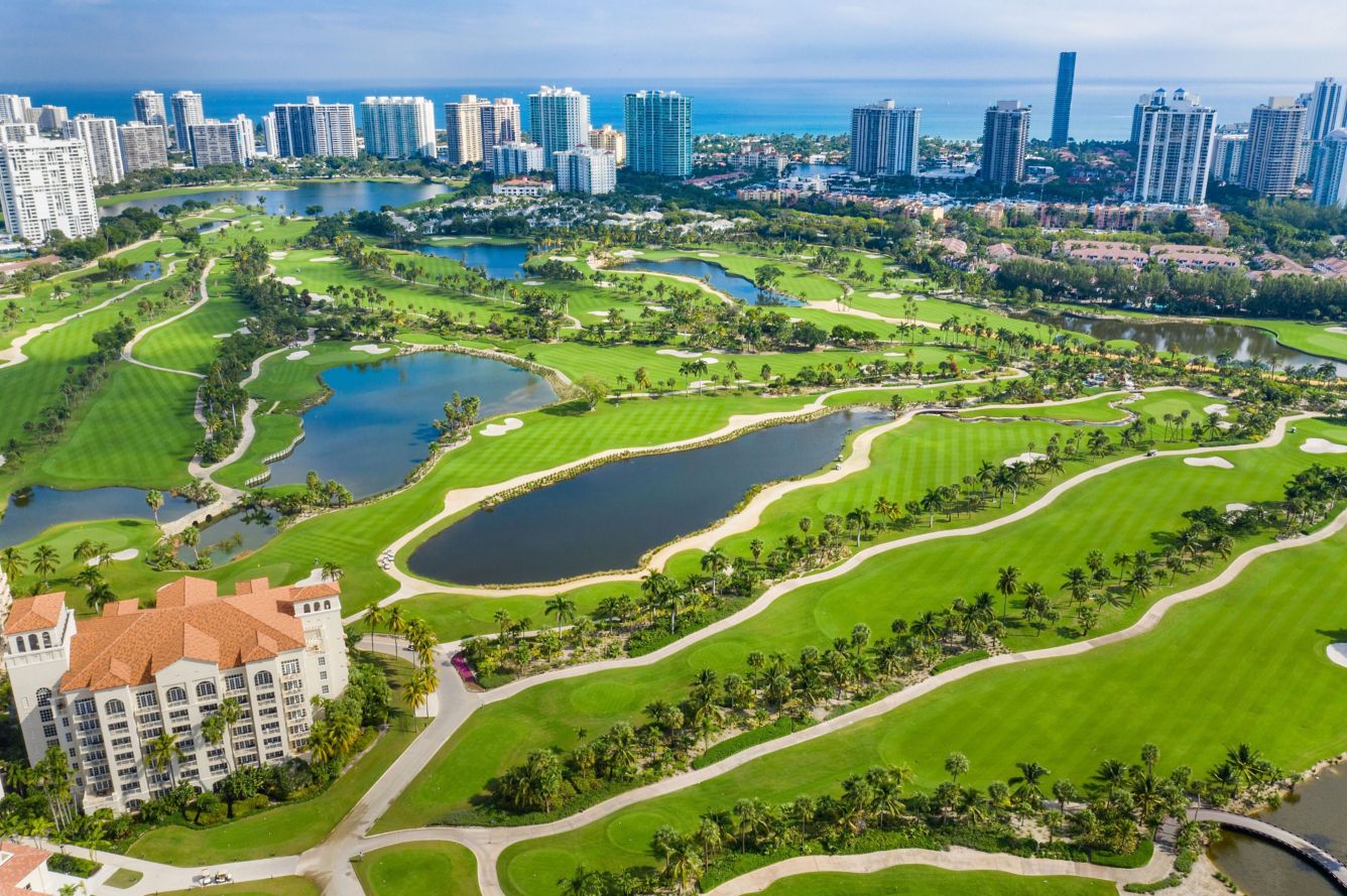 Aerial view of a golf resort with city skyline available for Miami weddings.