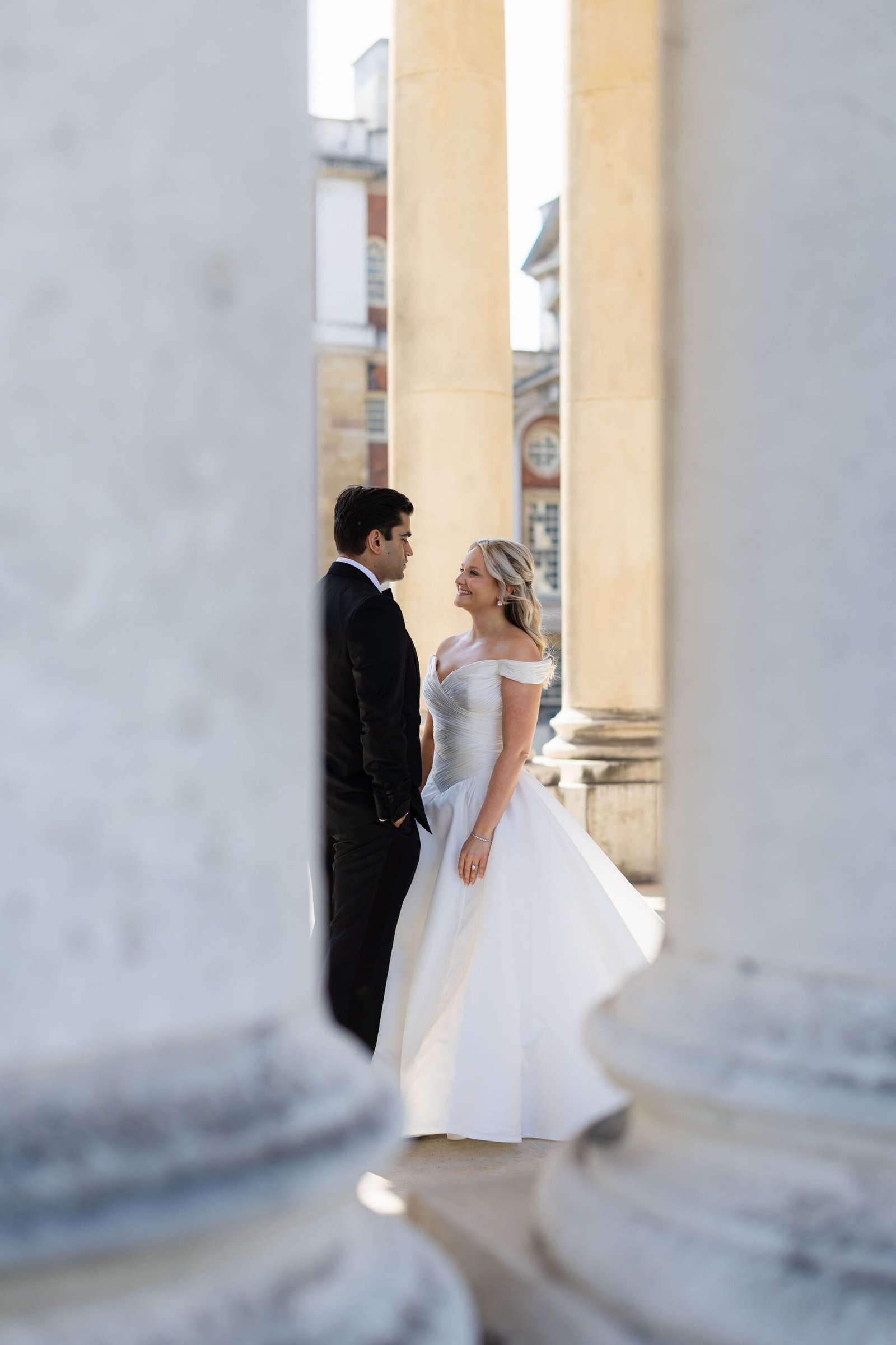 Bride and groom together beneath the stone colonnade of their London venue