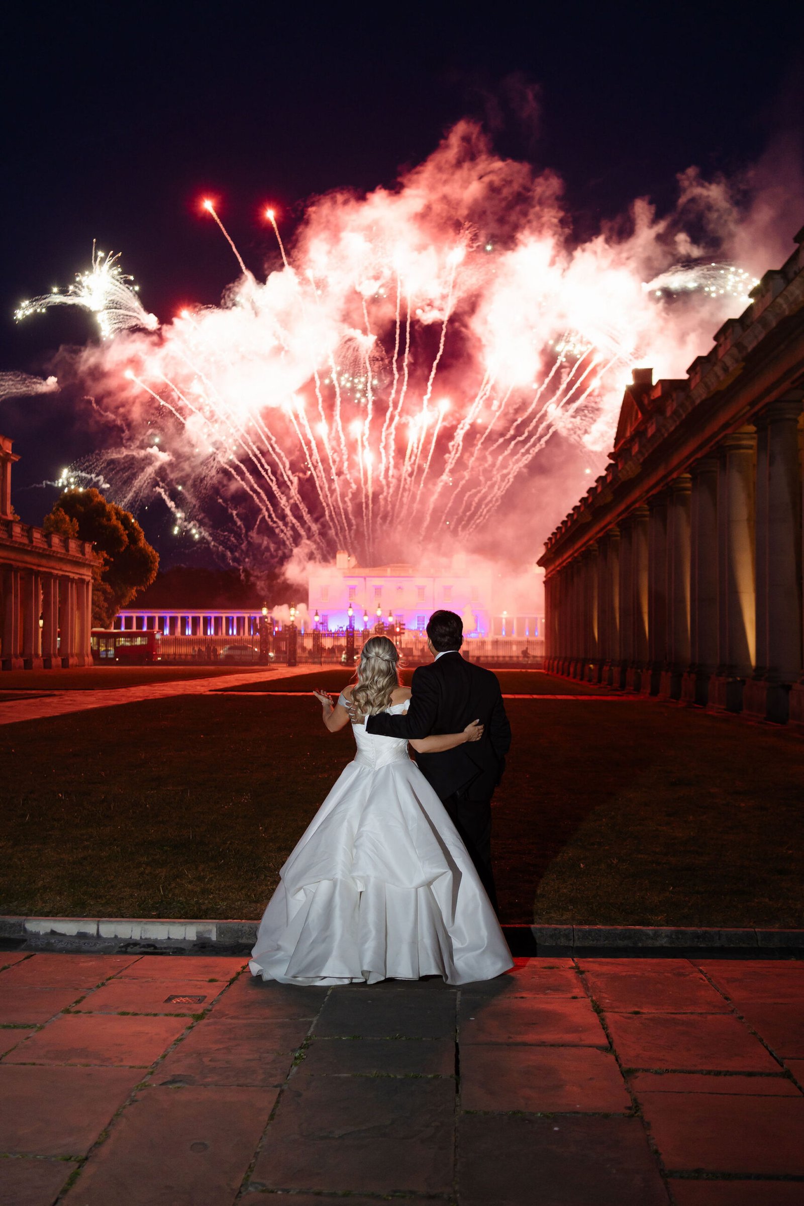 Bride and groom during a luxury wedding fireworks finale at night.
