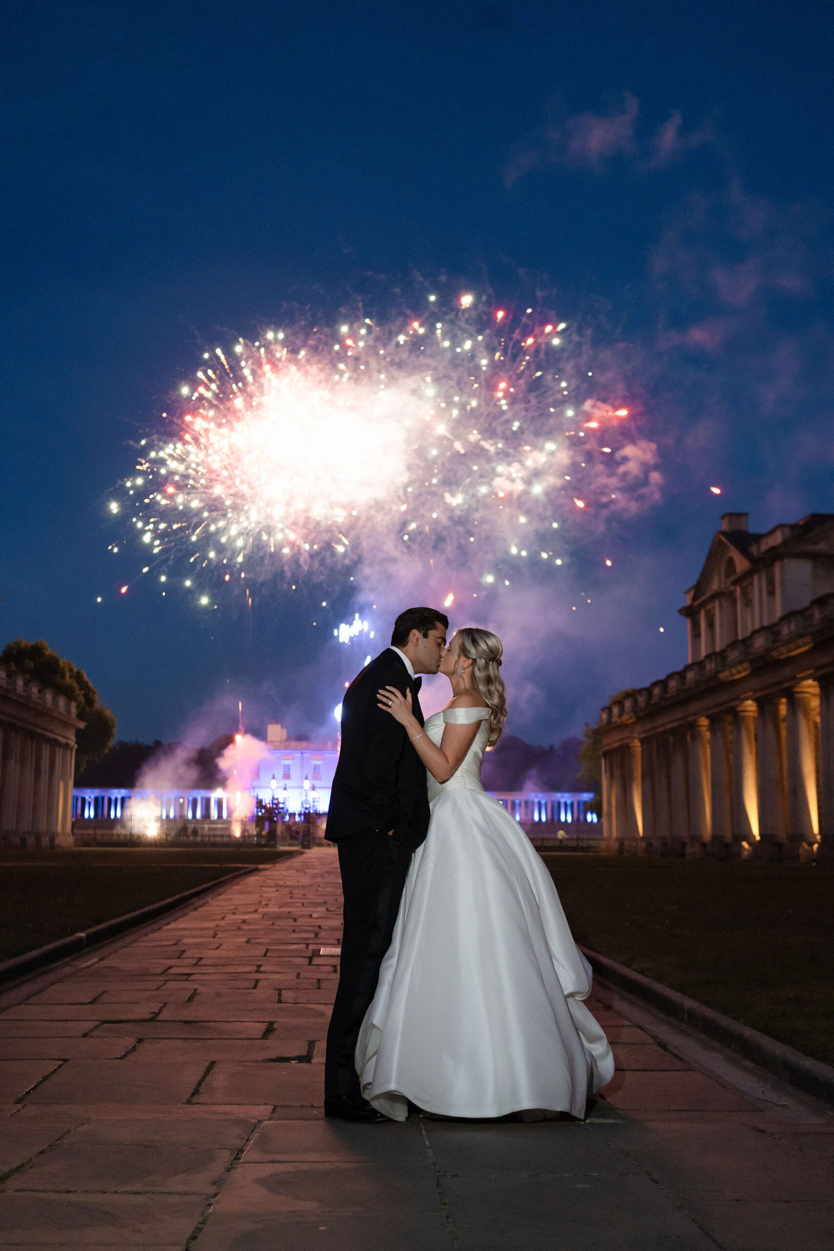 Bride and groom beneath a fireworks finale at a luxury wedding production