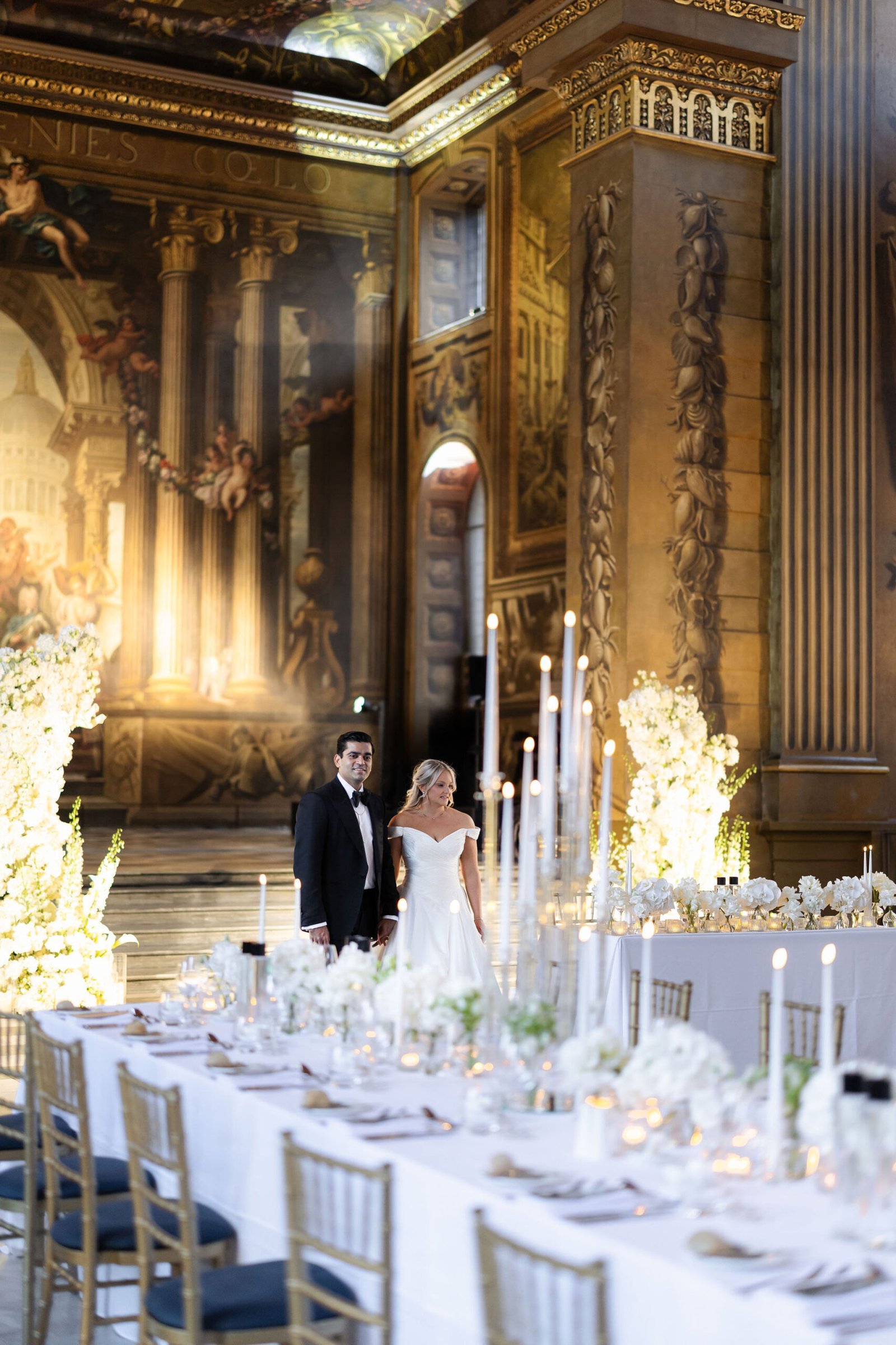 Bride and groom beside candlelit tables in their London wedding venue
