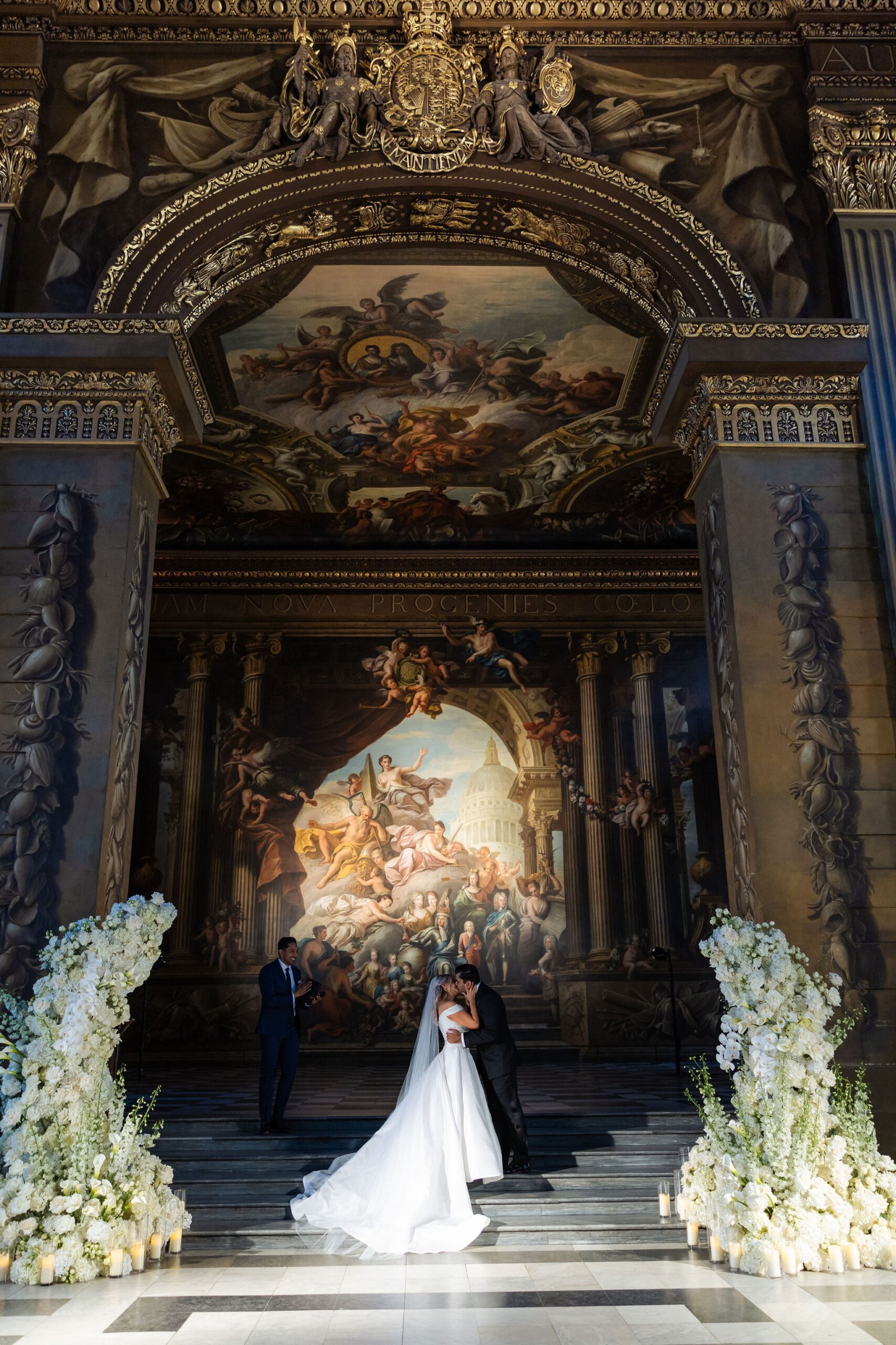 London wedding reception design inside an ornate historic hall with candlelight and long dining tables.
