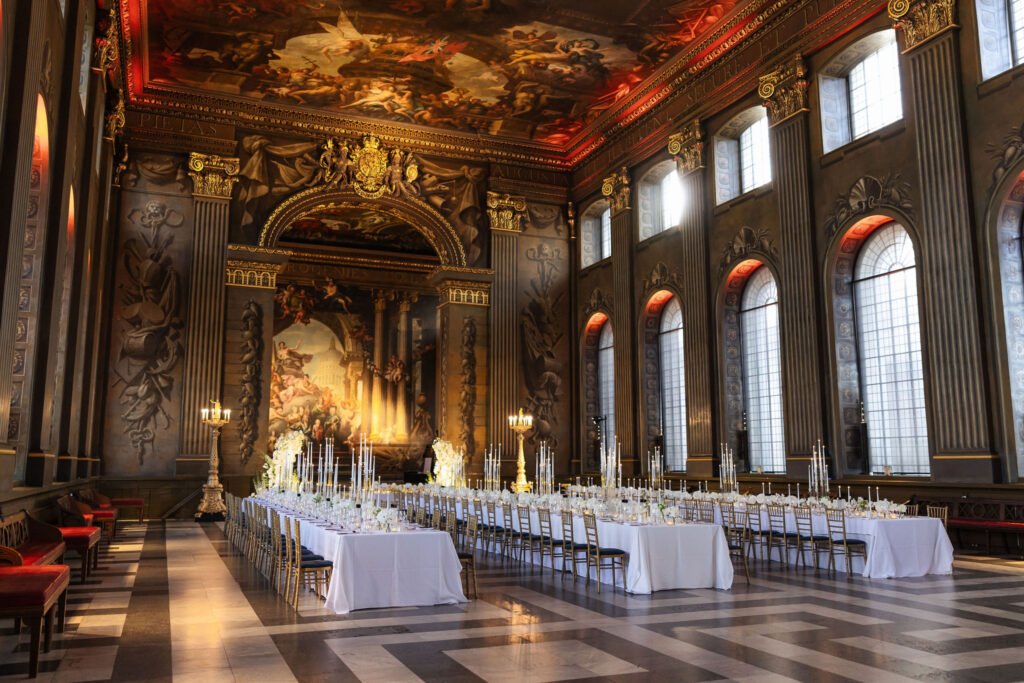 A long wedding reception table beneath a painted ceiling in London