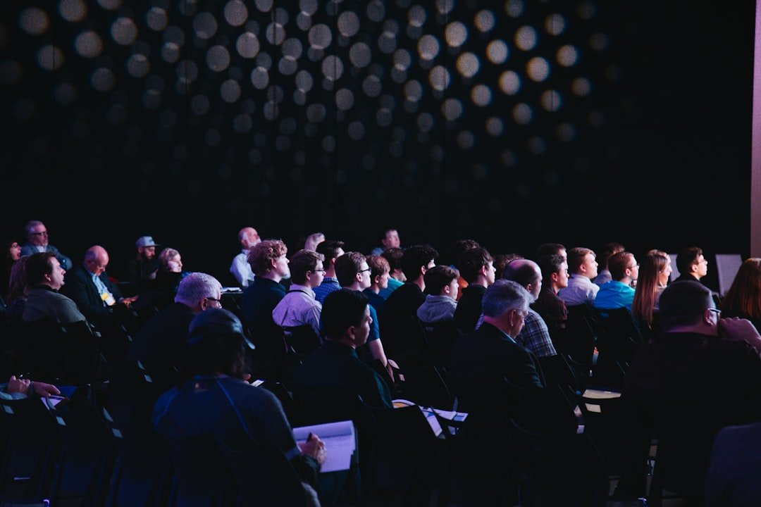 Guests seated at round tables beneath warm lights during a business gathering